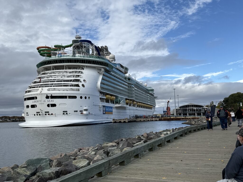 A picture of the backside of a cruise ship floating by a dock
